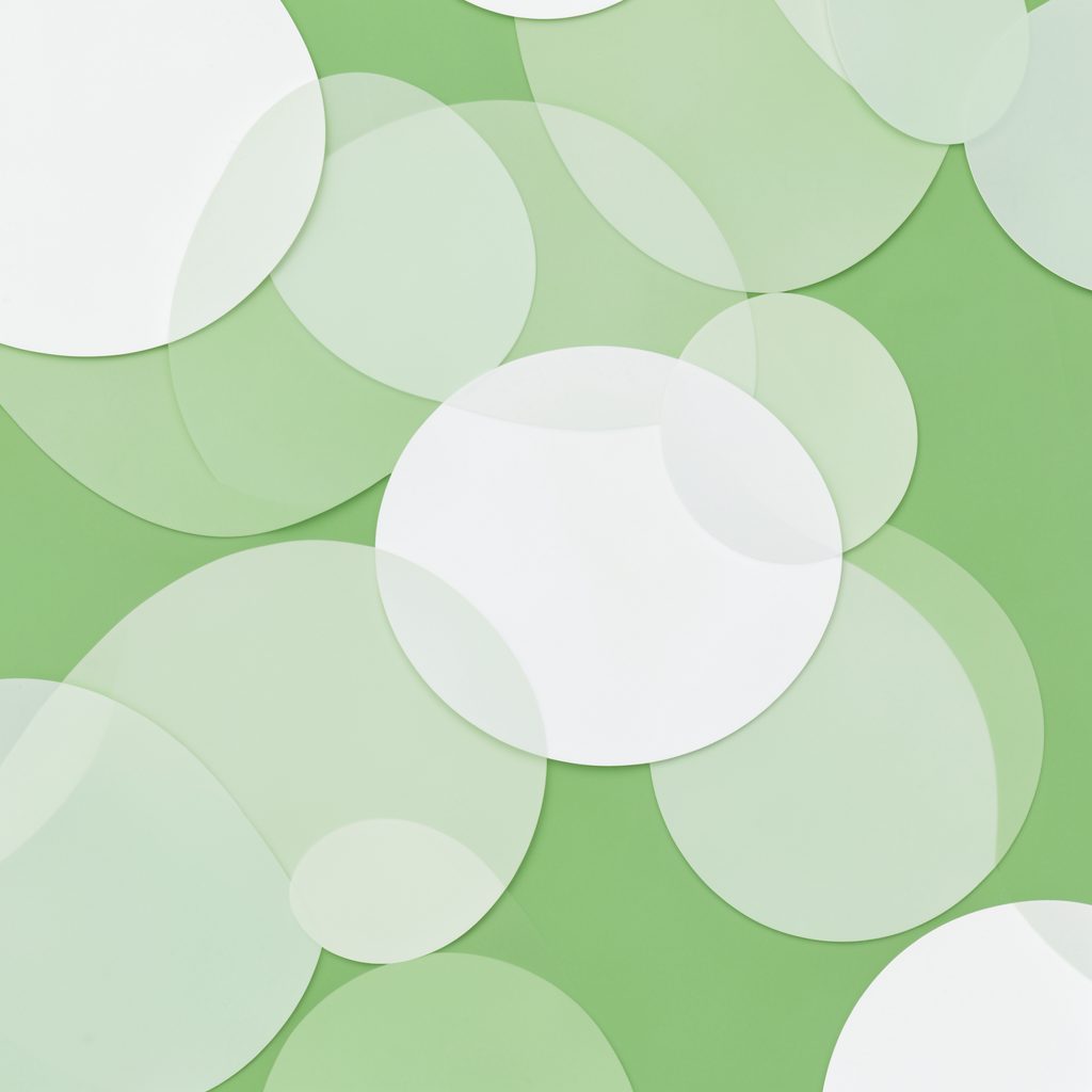 Soft overlapping circles in pale green and white, creating a light abstract pattern against a green background